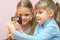 Two children considered coin through a magnifying glass