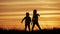 Two children dancing and enjoying nature on sunset. Child`s silhouette. Happy childs have fun, enjoying nature.