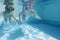 Two children diving in masks underwater