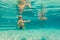 Two children diving in masks underwater in pool