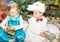 Two children dressed in carnival suits near christmas fir tree in New Year\'s children\'s holiday with gifts