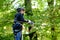 Two children in forest adventure park. Kids boys in helmet climbs on high rope trail. Agility skills and climbing