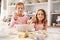 Two children having fun baking in the kitchen