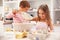 Two children having fun baking in the kitchen