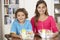 Two Children With Healthy Lunchboxes In Kitchen