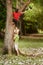 Two children helping and climbing on tree in park