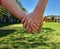 Two children hold hands closeup. Brother and sister walking together