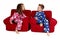 two children laughing wearing winter pajamas sitting in red chair