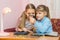 Two children looking at coin through a magnifying glass