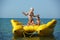 Two children with mom on the dinghy sailing at sea in summer