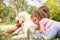 Two Children Petting Family Dog In Summer Field