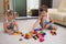 Two children playing with blocks on the floor at home