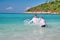 Two children playing in tropical sea. Kids playing In ocean surf on vacation. Cute boys splashing water on each other. Sunny day.