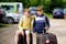 Two children, school boys sitting on suitcases before leaving for summer vacation camp. Happy kids, siblings, twins