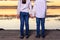 Two children shake hands on their backs at sunset by a lake, concept of friendship