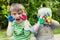 Two children showing painted hands outside