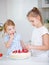 Two children snack on a strawberry cake