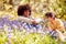 Two Children In Spring Woodlands Examining Bluebells With Magnifying Glass