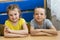 Two children at the table. cute elementary school kids in a classroom. A boy and a girl are sitting at the table. Portrait of