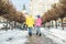 Two children talk and walk down the street in winter jackets and warm hats