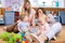 Two children with their moms playing with lots of colorful plastic blocks constructor sitting on a floor indoor