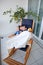 Two childs brothers big and small infant sit and play in rocking chair on terrace