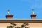 Two chimneys with unusual pipes on top with multiple openings and protective caps built on top of suburban family house roof