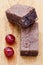 Two chocolate brownies with two glace cherries