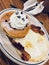 two chocolate chip pancakes, whipped cream, two fried eggs, two strips crispy bacon