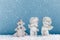 Two Christmas baby angels statuettes on snow with Christmas tree