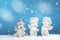 Two Christmas baby angels statuettes on snow with Christmas tree