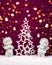Two Christmas baby angels statuettes on snow with Christmas tree