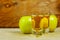 Two cider glasses and green apples