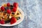 Two Classic Berry Waffles on a Rustic Blue Wood Table