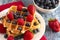 Two Classic Berry Waffles on a Rustic Blue Wood Table