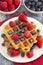 Two Classic Berry Waffles on a Rustic Blue Wood Table