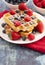 Two Classic Berry Waffles on a Rustic Blue Wood Table
