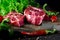 Two classic fresh ribeye steak on stone with herbs peppercorns over grey stone surface background top view