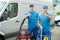 Two Cleaners Standing With Cleaning Equipments