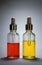 Two clear glass bottles with bright cosmetic oils yellow and re