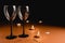 Two clinking wine glasses, candle, confetti on orange and black background. Minimal style and valentines day