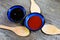 Two  close up bowls with black hoi sin and red hot spicy chili sauce with wood spoons on wood table