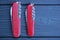 two closed folding knives with red handles