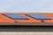 Two clusters of ten brand new solar panels mounted on top of renovated office building with new roof tiles