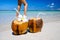 Two coconut cocktails on white sand beach with woman slim legs next to clean sea water. Vacation and travel concept