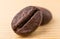 Two coffee beans on wooden table macro