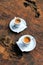 Two coffee espresso white cups with sugar sachets on natural brown wooden table,