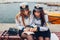 Two college women students of Marine academy reading book by sea wearing uniform. Friends studying