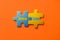 Two colored details of puzzle with text Know How on orange background, Yellow and Blue, close up