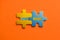 Two colored details of puzzle with text Next issue on orange background, Yellow and Blue, close up